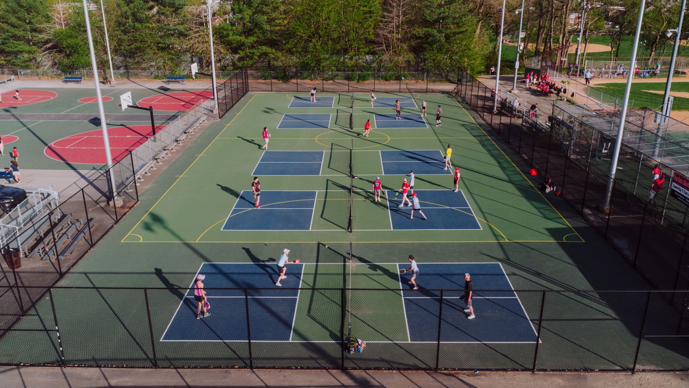Players on outdoor pickleball courts seen from above, illustrative stock photograph